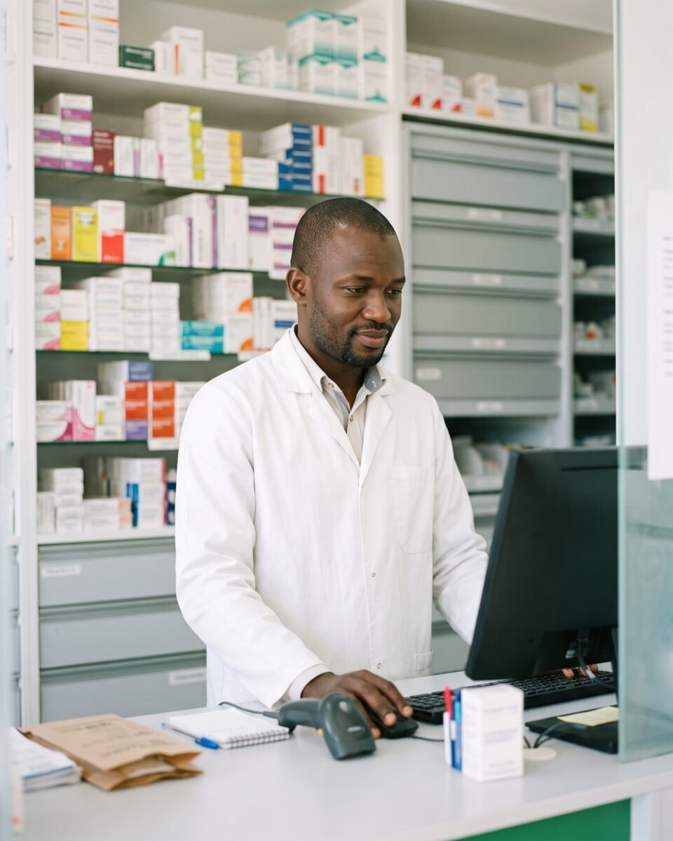 Pharmacien au comptoir devant son ordinateur